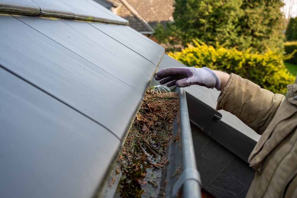 Gutter Painting and Home Protection Man,Cleaning,The,Blocked,Rain,Gutter.